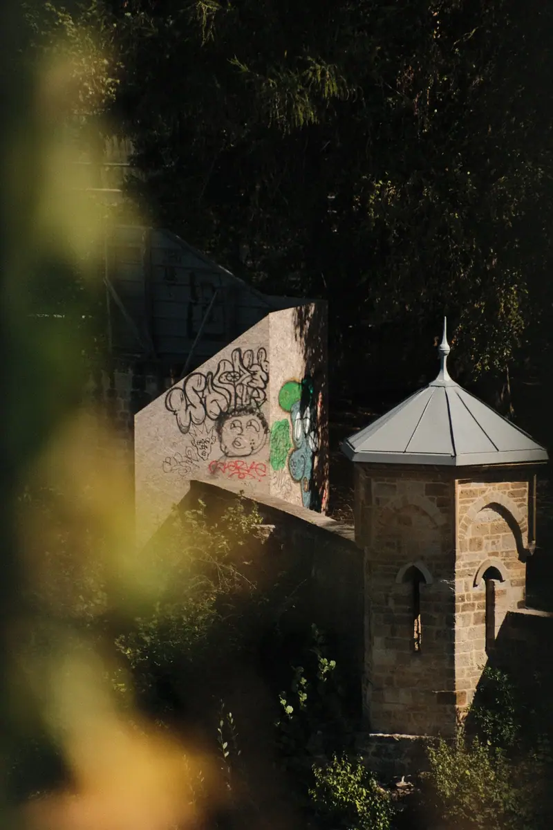 A turreted stone tower glimpsed through out-of-focus leaves