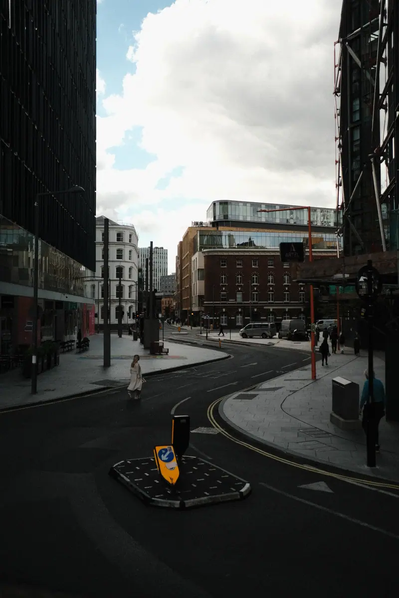 A quiet modern street corner, a yellow bollard on a small traffic island